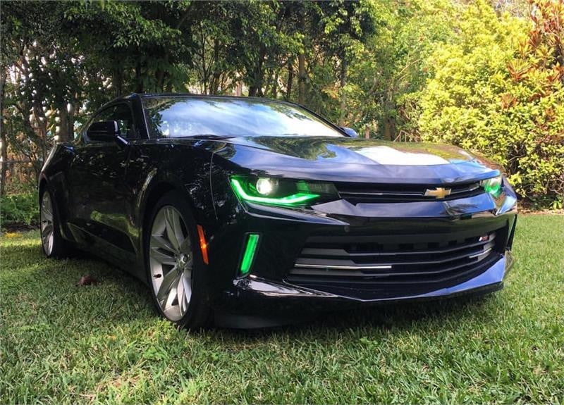 Black camaro on grass with green DRL