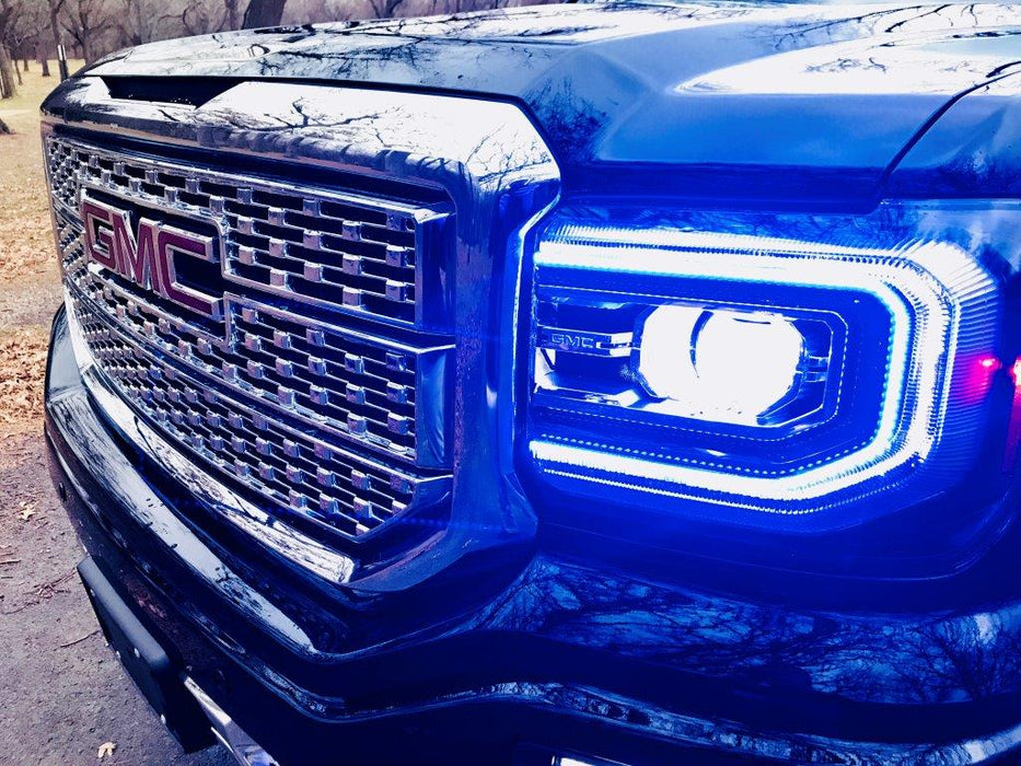 Close-up of a GMC Sierra headlight with blue DRLs.