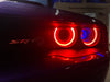 Close-up of a Dodge Challenger headlight with blue demon eye projector headlights.