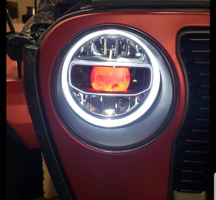 Close-up of a Jeep Wrangler headlight with amber "Demon Eye" Projector.