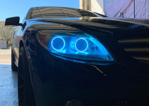 Close-up on the headlight of a Mercedes Benz CL 500 with cyan LED halo rings.