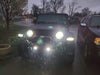 Jeep outdoors in the rain with bright LED Headlights, Fog Lights, and fender lights.