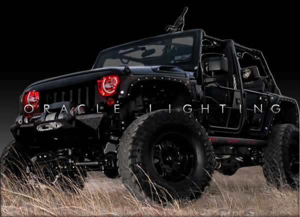 Three quarters view of a Jeep Wrangler JK with red LED headlight halo rings installed.