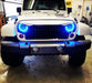 Front end of a Jeep Wrangler with 7" High Powered LED Headlights installed, and cyan halos on.