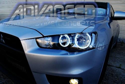 Close-up of a Mitsubishi Lancer headlight with white LED headlight halo rings installed.