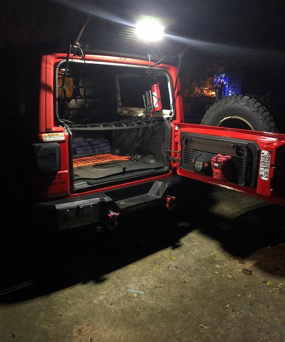Red jeep with trunk open and cargo light on