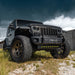 Low aggressive shot of a Jeep parked in the grass, equipped with LED Integrated Skid Plate and Vector Grill.