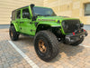 Three quarters view of a green Jeep Wrangler JL with Sidetrack™ LED Lighting System installed.