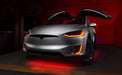 Silver Tesla Model X with red headlight and fog light DRLs.