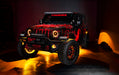 Three quarters view of a red Jeep Wrangler JL, with ColorSHIFT Oculus Headlights, and amber halo rings.