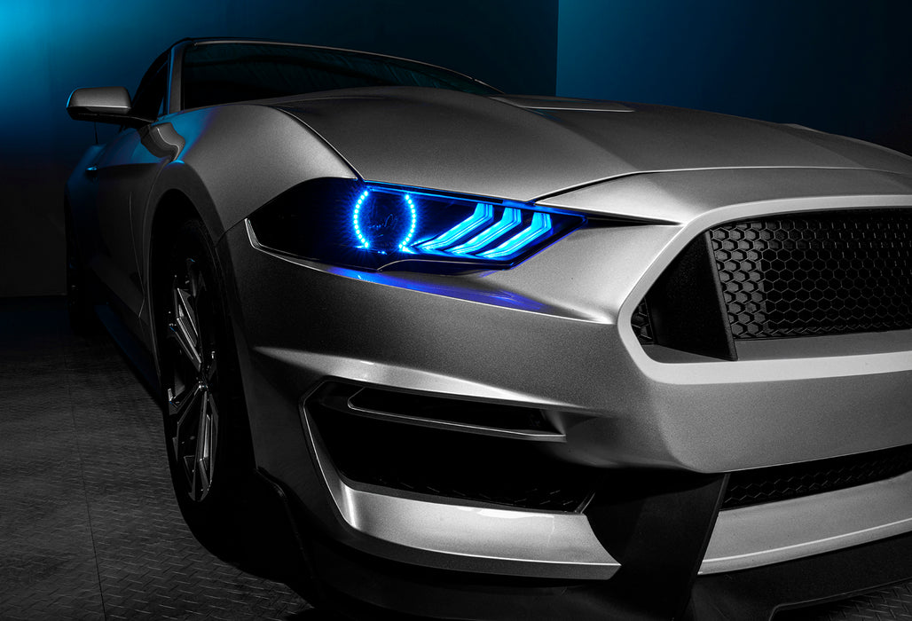 Close-up on a Ford Mustang headlight with cyan halos and DRLs.