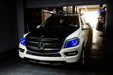 Three quarters view of a Mercedes GL Class with blue headlight halos and DRLs.