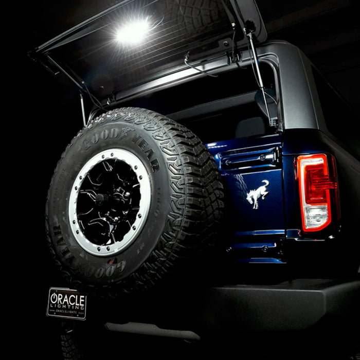 Rear view of bronco with trunk open and cargo light module shining in the dark