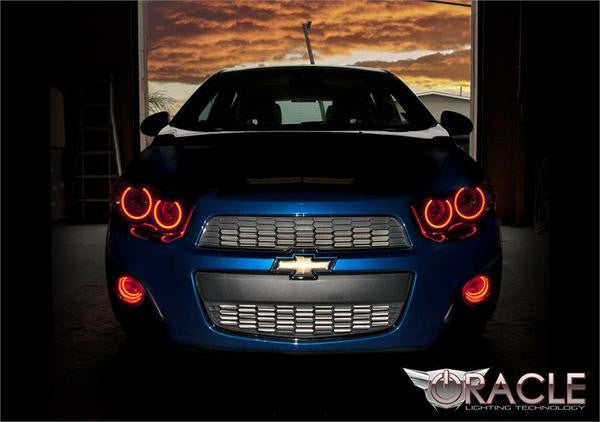 Front end of a Chevy Sonic with red LED headlight and fog light halo rings installed.