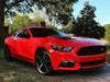 Three quarters view of a red Ford Mustang with rainbow headlight halos and DRLs.