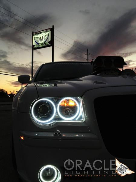 Close-up of white LED headlight and fog light halo rings installed on a Chrysler 300.