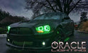 Three quarters view of a Dodge Charger with green LED headlight and fog light halo rings installed.