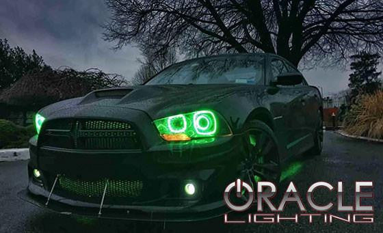 Three quarters view of a Dodge Charger with green LED headlight and fog light halo rings installed.