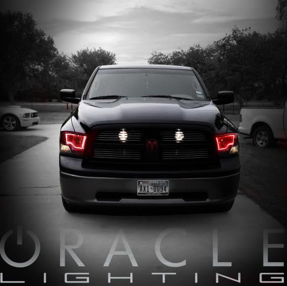 Front view of a black Dodge Ram with red LED headlight halo rings installed.