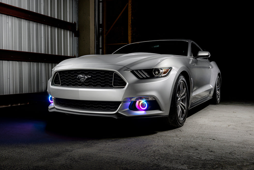 Three quarters view of a silver Ford Mustang with rainbow fog light halos.