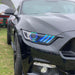 Close-up of a Ford Mustang headlights with multicolored halos and DRLs.