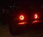 Jeep in the dark with only red halo headlights being visible