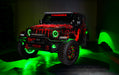 Three quarters view of a red Jeep Wrangler JL, with ColorSHIFT Oculus Headlights, and green halo rings.