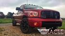 Front end of a Dodge Ram with red LED headlight and fog light halo rings installed.