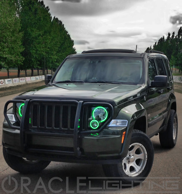 Three quarters view of a Jeep Liberty with green LED headlight halo rings installed.