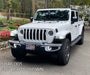 Three quarters view of a white Jeep Gladiator equipped with Oculus Headlights.