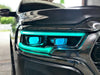 Extreme close-up of a Ram 1500 headlight with cyan DRLs and cyan demon eye projectors.