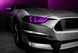 Close-up on a Ford Mustang headlight with pink halos and DRLs.