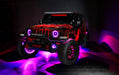 Three quarters view of a red Jeep Wrangler JL, with ColorSHIFT Oculus Headlights, and pink halo rings.