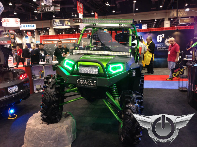 Polaris RZR in a showroom, equipped with green LED headlight halos.