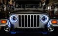 Front end of a Jeep with white LED headlight halo rings installed.